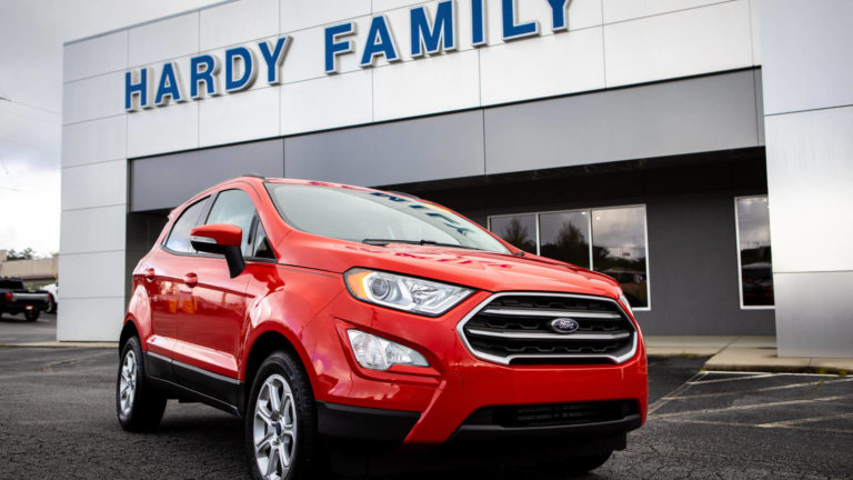a red ford cuv parked in front of the Hardy Family dealership building